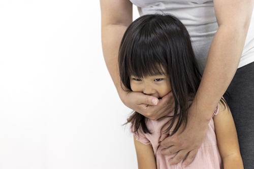 女児の口を塞ぐ成人男性
